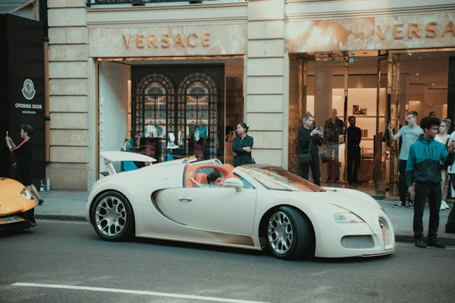 White Porsche 911 parked outside an elegant building