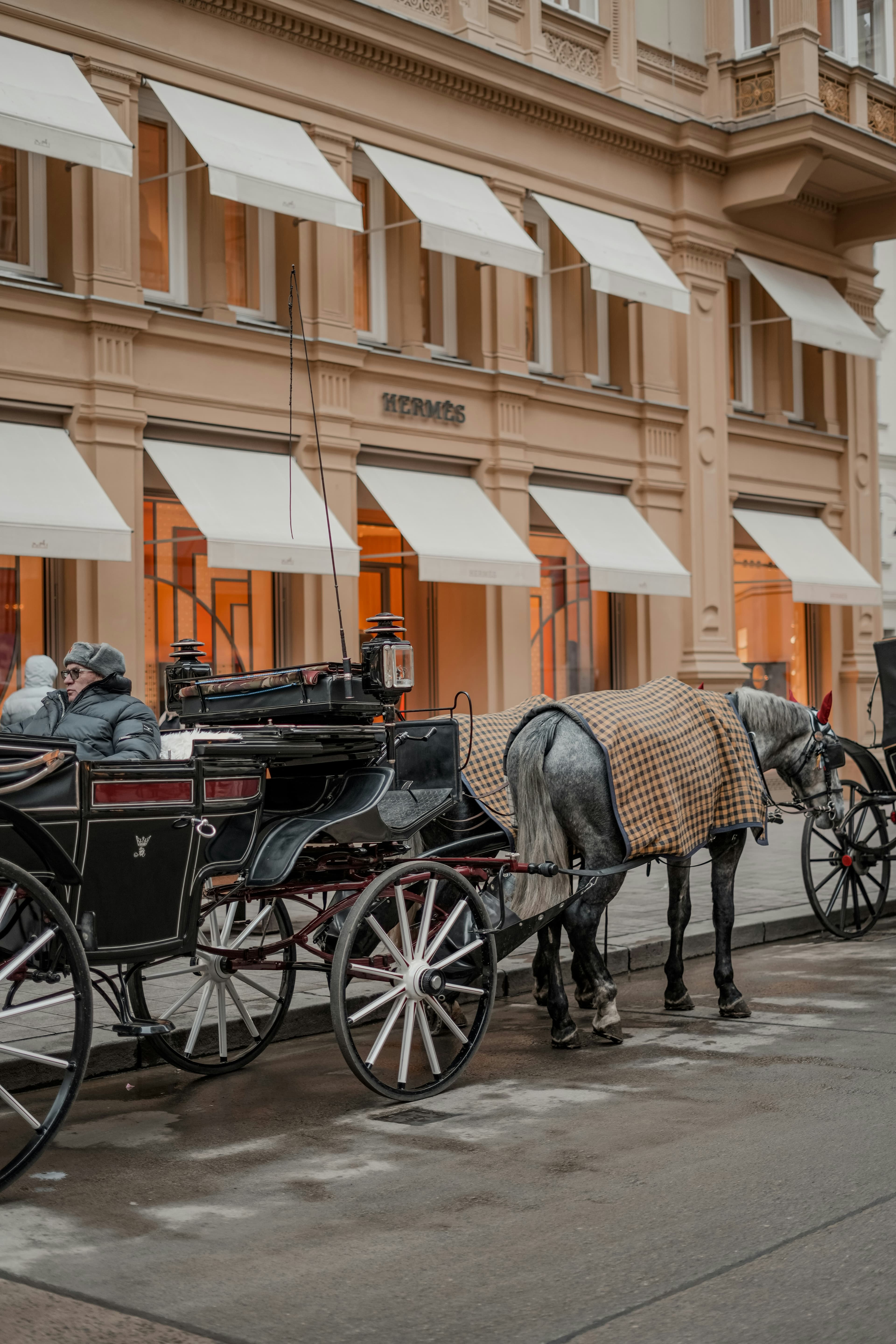 A horse-drawn carriage outside a Hermès boutique