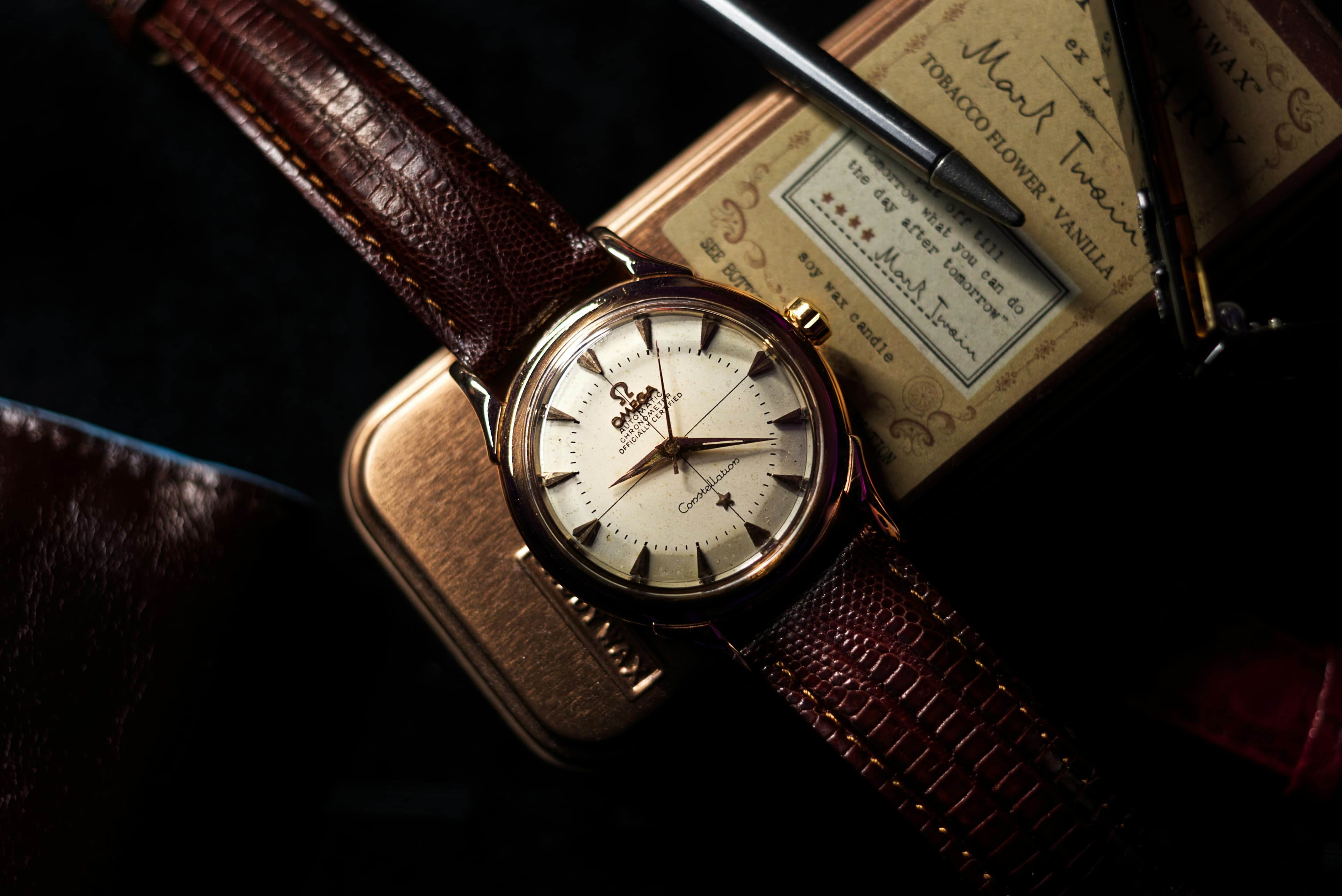 A wristwatch resting on a brown case