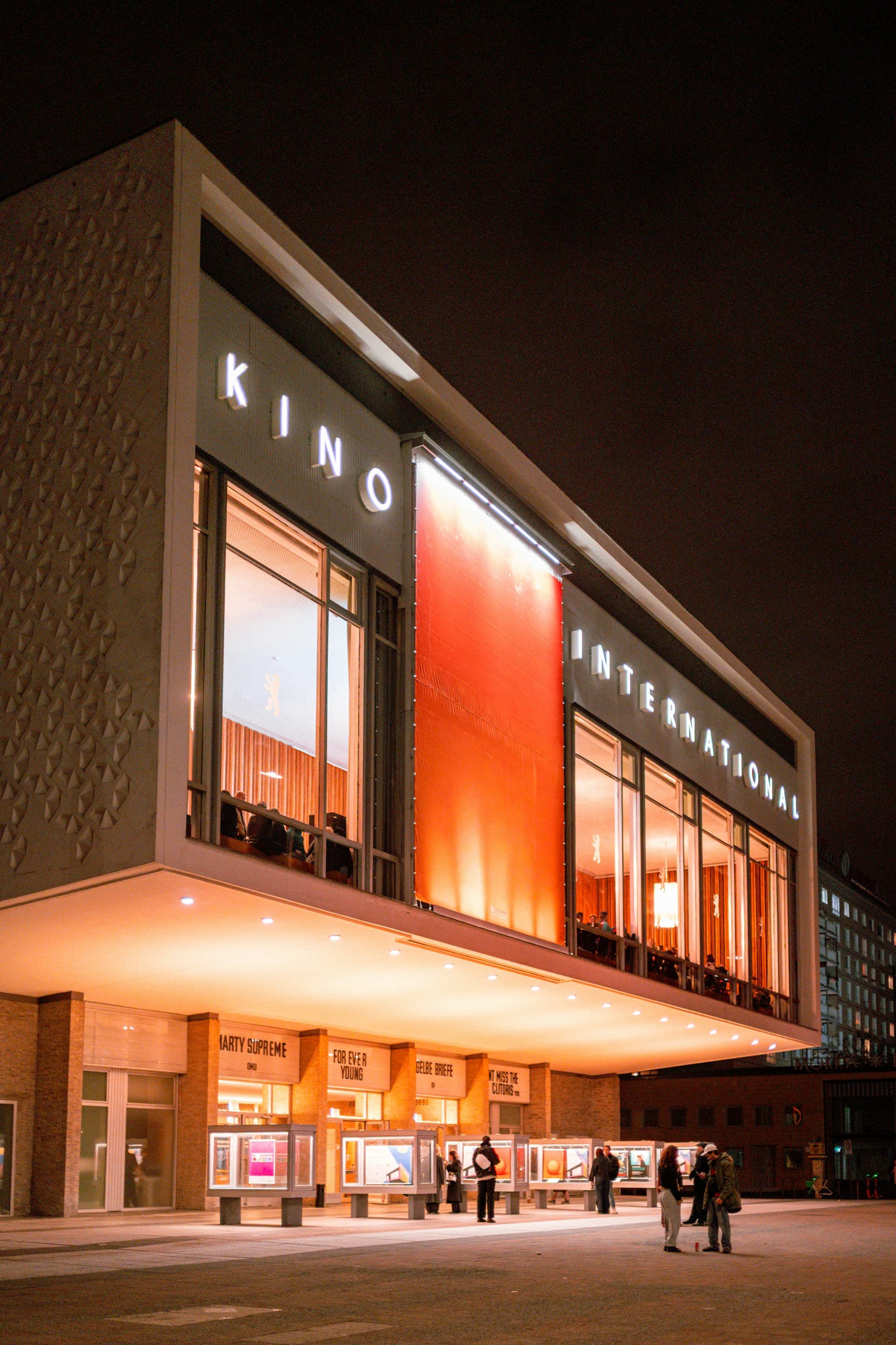Kino International cinema illuminated at night in Berlin, Germany.